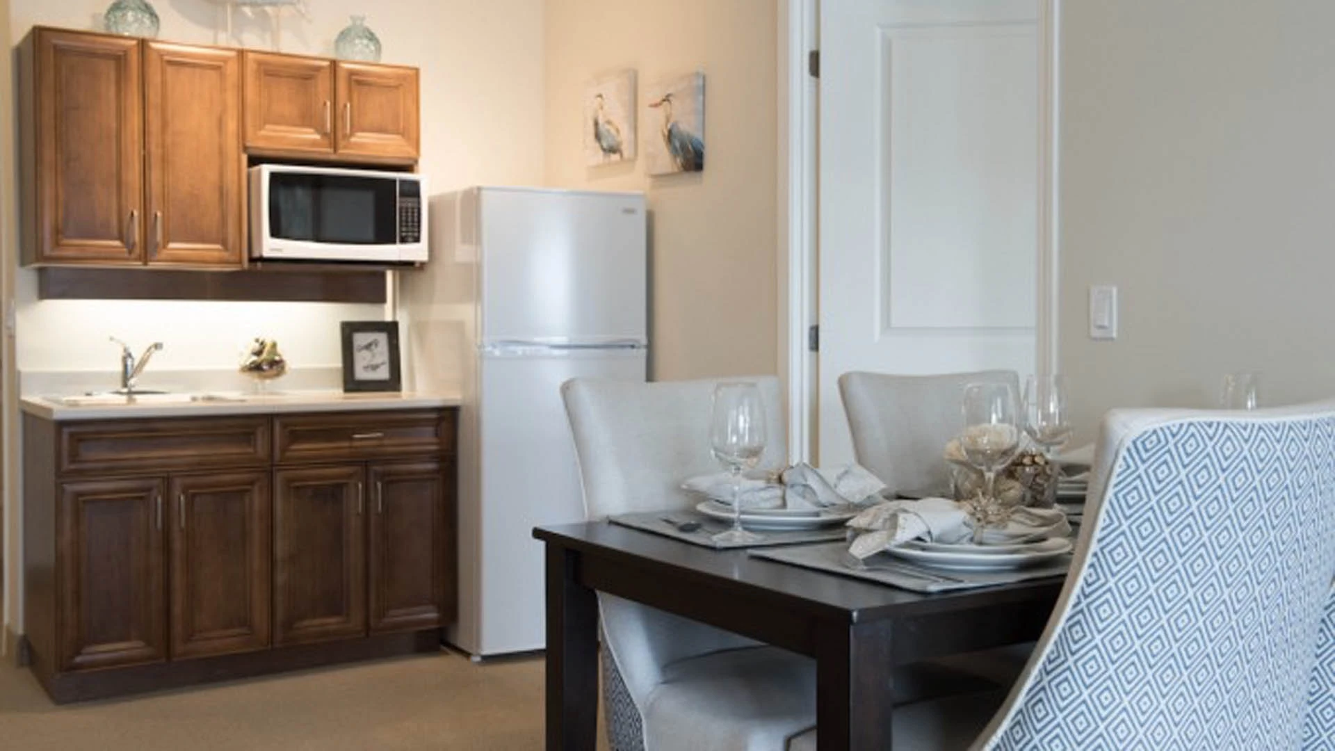 Senior apartments kitchen and table set with plates and glasses.