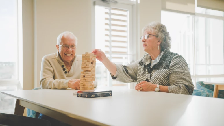 Two seniors building a jenga tower