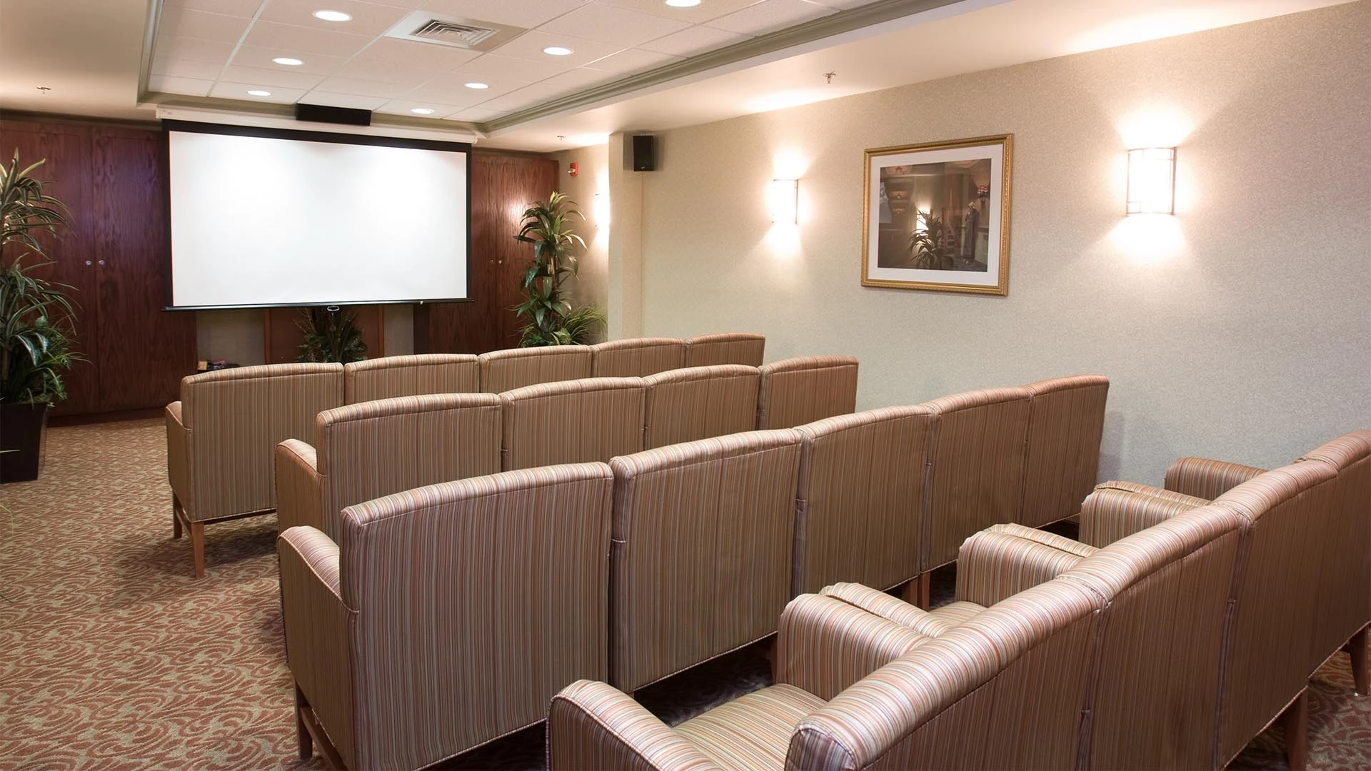 Rows of chairs and a movie screen in the Rutherford Heights senior living movie room