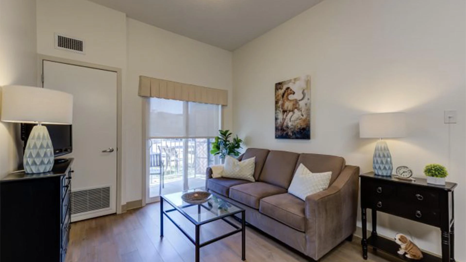 Senior apartments living room with tv, stand, couch, and side table at Rutherford Heights