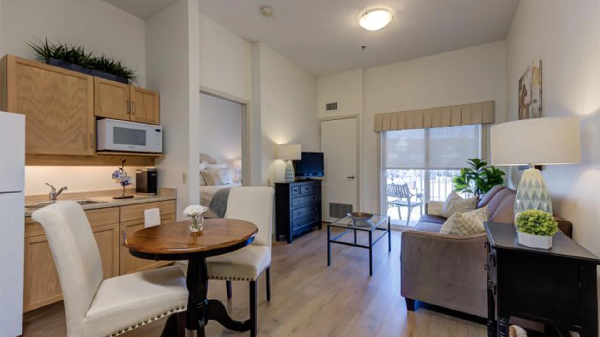 Senior apartments with a kitchenette, bedroom door, and living room at Rutherford Heights